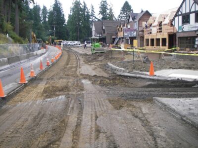 street in the middle of being repaved with large equipment by businesses